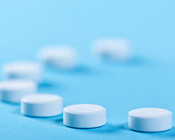 Two tampons and a white menstrual cup against a red background