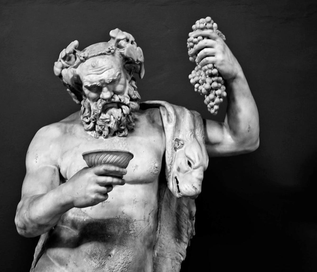 A black and white image of a statue of Dionysus holding a goblet and grapes