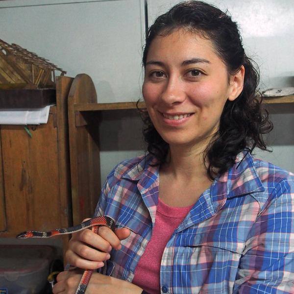 Roboticist Talia Yuki Moore holding live snake that is a model for one of her robots.